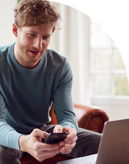 Man using laptop and mobile at work