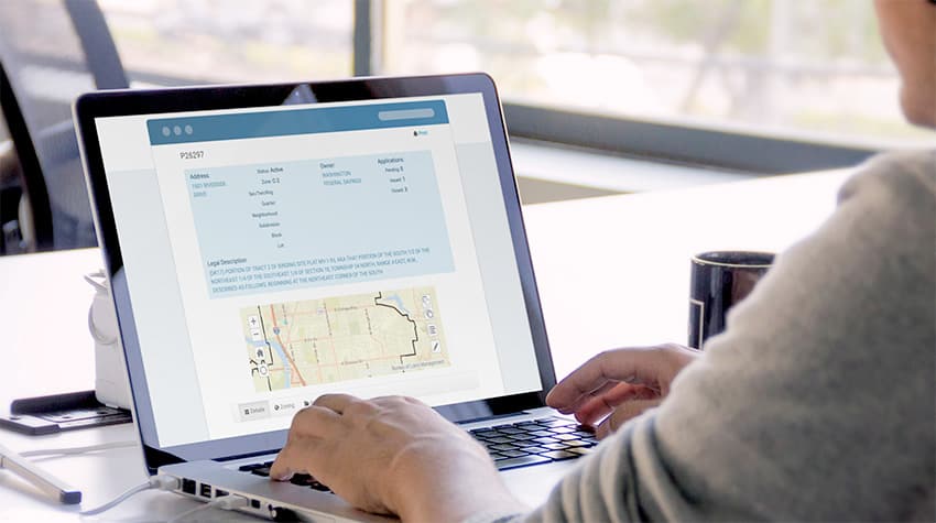 A man sitting at his laptop reviewing his permits in the SmartGov permitting & licensing portal